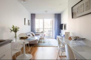 una sala de estar blanca con mesa y sillas en Fresh and cosy apartment in the center of the city, en Estocolmo