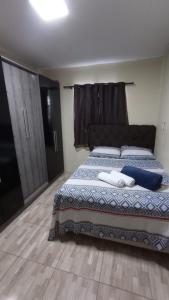 a bedroom with a bed with blue and white sheets at Kitnet Rioli in Caruaru