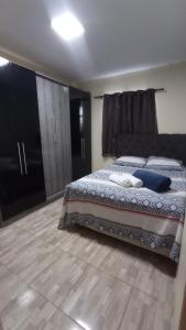 um quarto com uma cama grande e piso em madeira em Kitnet Rioli em Caruaru