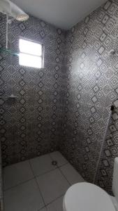 La salle de bains est pourvue de toilettes et d'une fenêtre. dans l'établissement Kitnet Rioli, à Caruaru