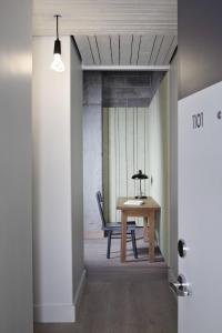 a table and a chair in a room with a hallway at Boro Hotel in Queens