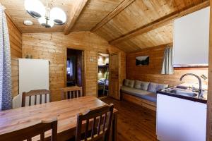 a kitchen and dining room of a log cabin with a wooden ceiling at Korsbakken Camping in Isfjorden