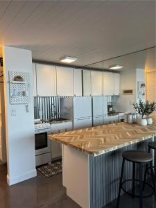a large kitchen with white cabinets and a wooden counter top at Sapphire Shores- Oceanfront at Symphony Beach Club in Ormond Beach