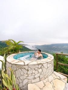 un hombre en un jacuzzi en una bañera de piedra en Glamping San Pedro, en San Gil