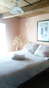 a bedroom with a bed with a pillow and a vase of flowers at Chez ROMU in Rieutort