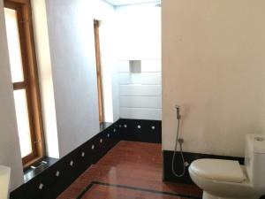 bagno con servizi igienici e finestra. di Karikkathi Beach Villa rooms a Trivandrum