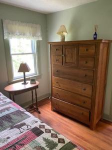 a bedroom with a dresser and a bed and a table at Blueberry Cottage Lake Champlain in Plattsburgh