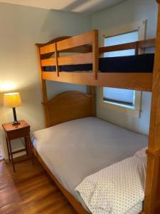 a bedroom with two bunk beds and a lamp at Blueberry Cottage Lake Champlain in Plattsburgh