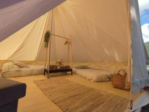 a tent with a couch and a table in a room at CAMPING LA ZARAPICA - Palacios del Sil in Palacios del Sil