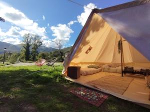 ein großes Zelt mit einem Bett im Gras in der Unterkunft CAMPING LA ZARAPICA - Palacios del Sil in Palacios del Sil