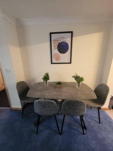 a dining room table with two chairs and a table with plants on it at Stunning seaside town cottage in Cardigan