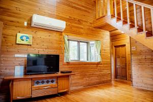 - un salon avec une télévision et un mur en bois dans l'établissement Yes Homestay, à Nanzhuang