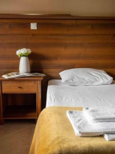 a bedroom with a bed and a vase of flowers on a table at Karyon Apartments in Kariófiton