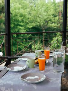 una mesa con platos de comida y vasos de zumo de naranja en Karyon Apartments en Kariófiton