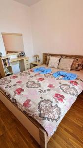 ein Schlafzimmer mit einem großen Bett mit einer Blumenbettdecke in der Unterkunft Beachfront Gem in Varna Center in Warna