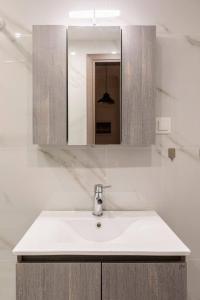 een witte wastafel in een badkamer met een spiegel bij Perfect Apartment 71B in Thessaloniki