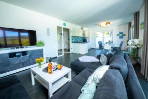 ein Wohnzimmer mit einem Sofa und einem Tisch in der Unterkunft Ferienhaus Familienjuwel am Diemelsee in Diemelsee