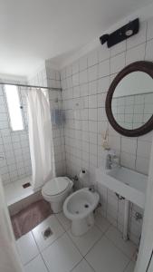 een badkamer met een toilet, een wastafel en een spiegel bij Departamento Céntrico Chaco in Resistencia