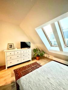 um quarto com uma televisão e uma cómoda num sótão em Apartament Gdański Słoneczny Nr 34 em Gdansk