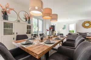 a dining room with a wooden table and chairs at Villa-Grenzenlos in Glowe