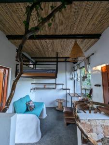 a living room with a tree in the ceiling at Four Trees Jungle Lodge in San Juan del Sur