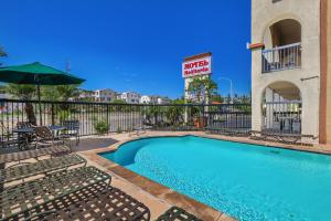 a swimming pool with chairs and a hotel sign at Motel Mediteran in Escondido