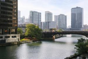 a bridge over a river in a city with tall buildings at Sonder The Burnham in Chicago