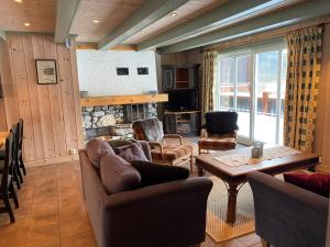 a living room with couches and a table and a fireplace at Fredheim Farm, Hemsedal - THE YARD in Hemsedal