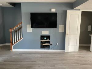 a living room with a flat screen tv on a blue wall at Luxury Townhome 2 Remodeled February 2021 in Bloomington