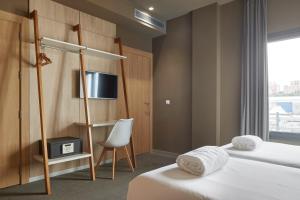 a hotel room with two beds and a tv at Hotel Landaben in Pamplona