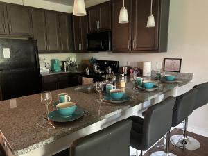 a kitchen with a table with plates and wine glasses at Cozy 2BR/2Bath Oasis 10 Minutes Away From Fort Lee in Brandermill