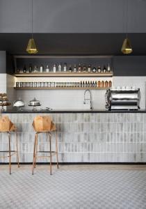 a kitchen with two stools in front of a counter at Boro Hotel in Queens