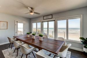 a dining room with a table and chairs and the ocean at Oceanfront Pool House 7 Bedrooms 7 Bath 2 Kitchens in Port Orange