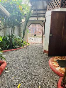 a garage with a gate and a driveway with a door at La Casa de Rolando in Puerto Viejo