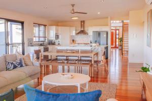 cocina y sala de estar con mesa y sillas en Cheerful family home with stunning views, en Caloundra