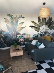 a living room with a couch and plants on the wall at Beautiful flat with balcony and sea view in Saint-Laurent-du-Var