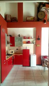 uma cozinha com armários vermelhos e uma parede vermelha em La Casita em Reggio di Calabria
