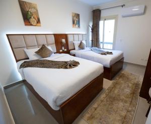 Gleem Luxury Apartments في الإسكندرية: غرفة نوم بسريرين ونافذة