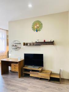a living room with a flat screen tv and a desk at Kael Apartman 02 in Teplice