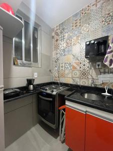 uma cozinha com um fogão e um lavatório em Confortável apto cama queen e sofá cama - COPACABANA no Rio de Janeiro