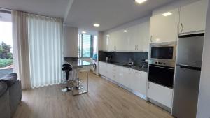 een keuken met witte kasten en een tafel. bij Sol do Til Apartment in Funchal
