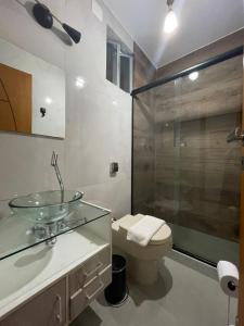 uma casa de banho com um lavatório de vidro e um WC. em Confortável apto cama queen e sofá cama - COPACABANA no Rio de Janeiro
