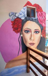 a painting of a woman on the side of a wall at Hotel Los Arcos Holbox in Holbox Island