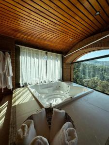 コンセイサオン・ダ・イビティポカにあるPousada Quinta do Baraoの大きなバスルーム(バスタブ、窓付)