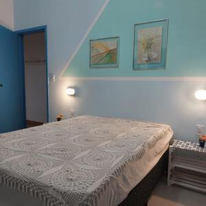 una camera da letto con un letto e due quadri sul muro di Pé na Areia - Casa para temporada a São Sebastião