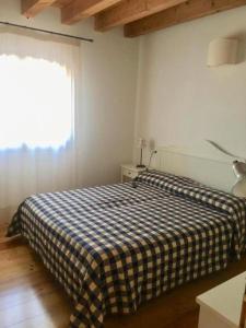 ein Schlafzimmer mit einem Bett mit einer karierten Decke in der Unterkunft Residenze Di La' Dal Fiume in Caorle