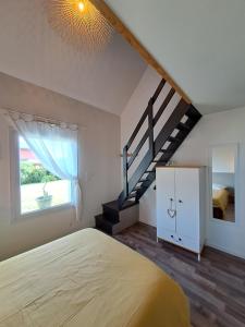 a bedroom with a bed and a staircase at Maison traditionnelle et moderne avec vue mer in Tréffiagat