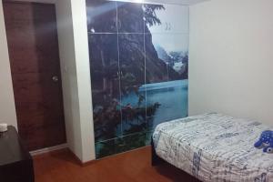 阿雷基帕的住宿－Casa a 10 min del centro y 15 min de Perumin，卧室,墙上挂着一幅画,床边是