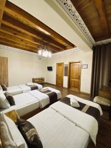 a row of beds in a room with wooden ceilings at Nostalgia Boutique Hotel in Bukhara