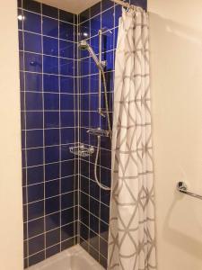 a bathroom with a shower with a blue tiled wall at Ferienwohnung Zum Strandvoigt in Sassnitz